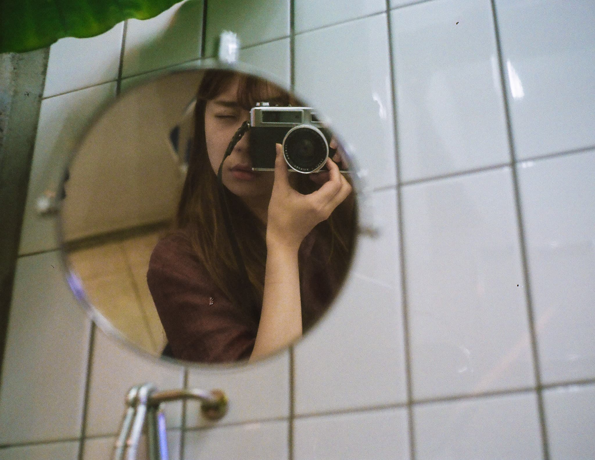 거울에 비친 나를 카메라 뷰파인더로 보고 있는 나의 얼굴 반쪽을 찍는 내가 담긴 사진