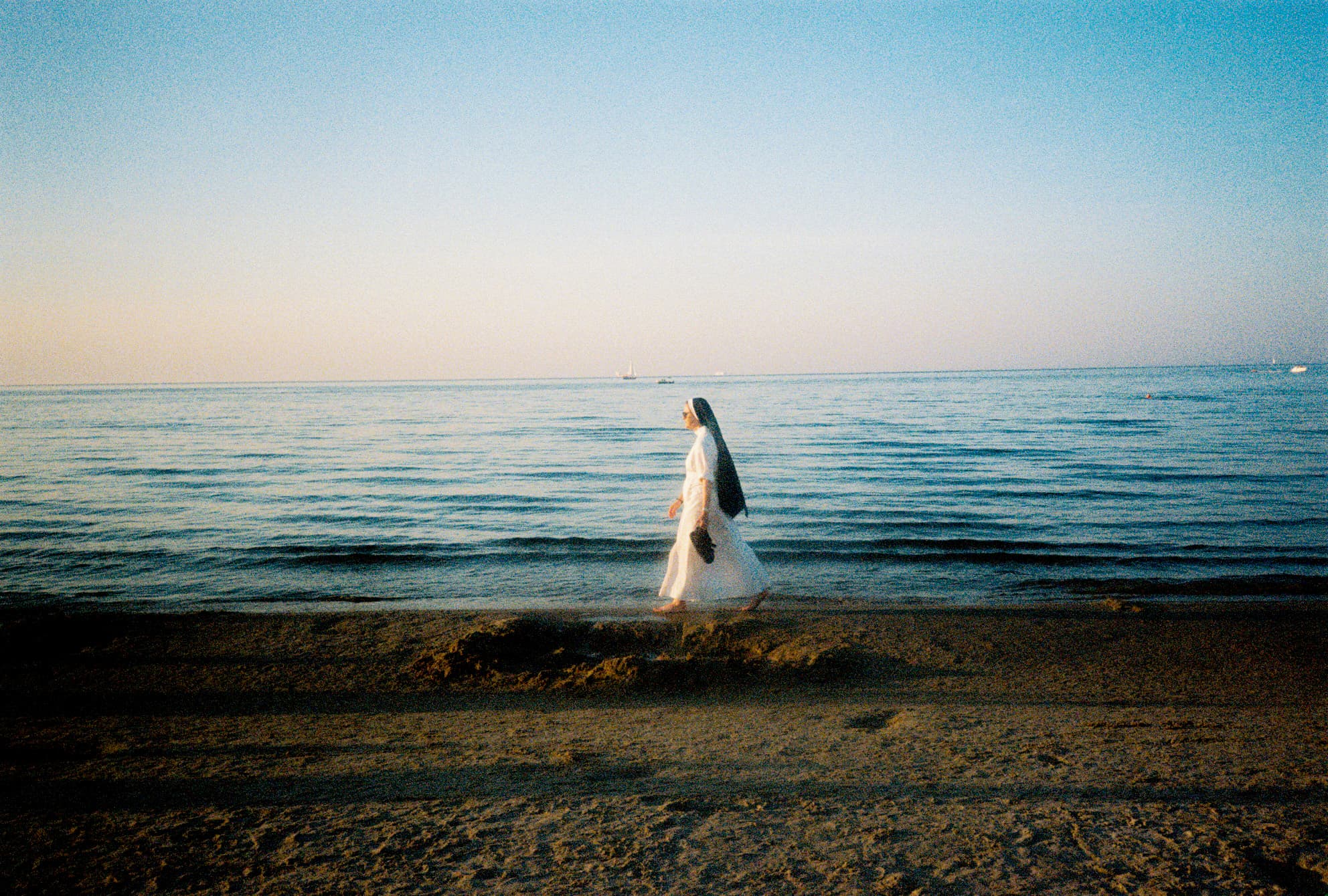 A nun walking by the sea. Baltic sea.